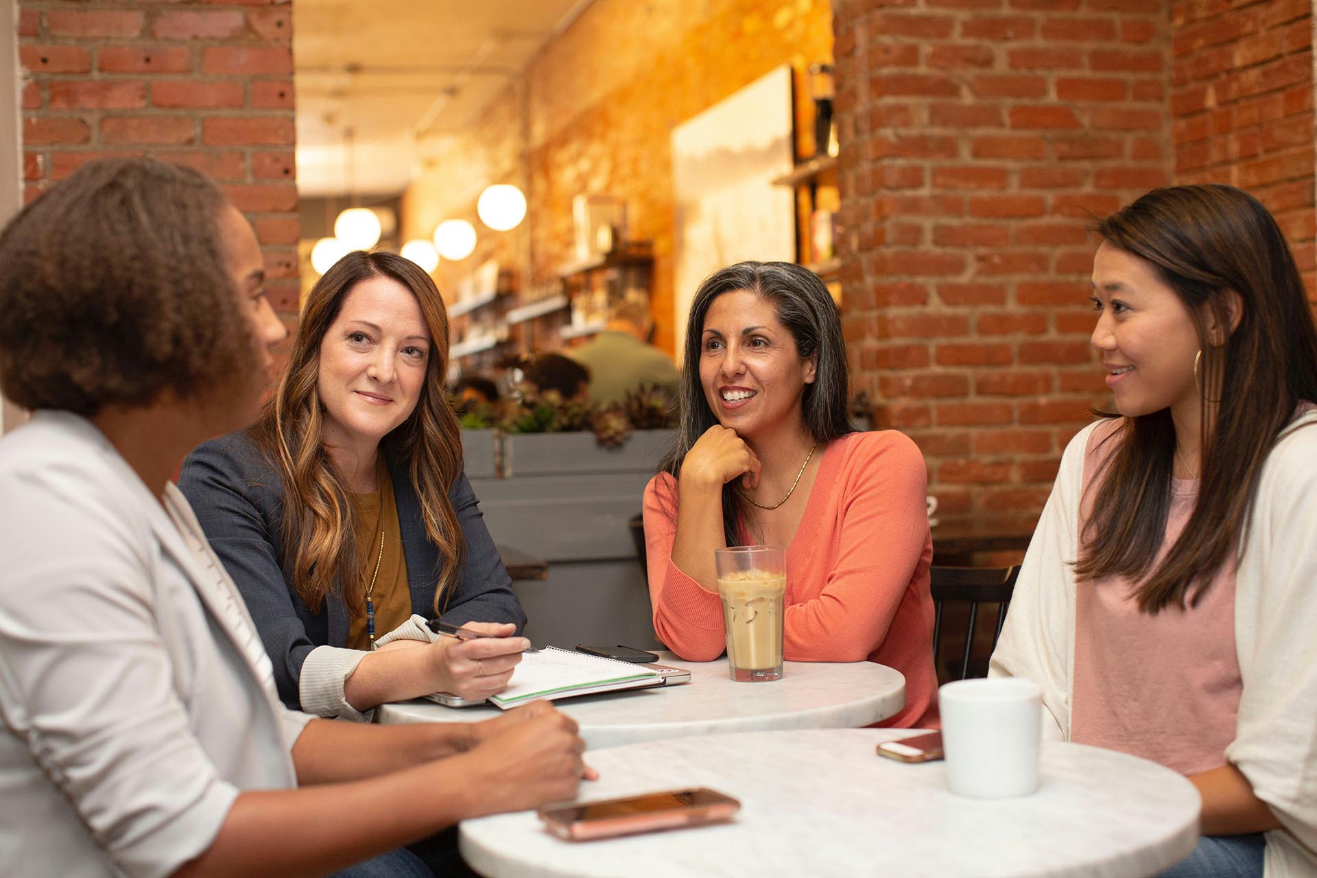 Four Women Working In A Business Meeting In A Café