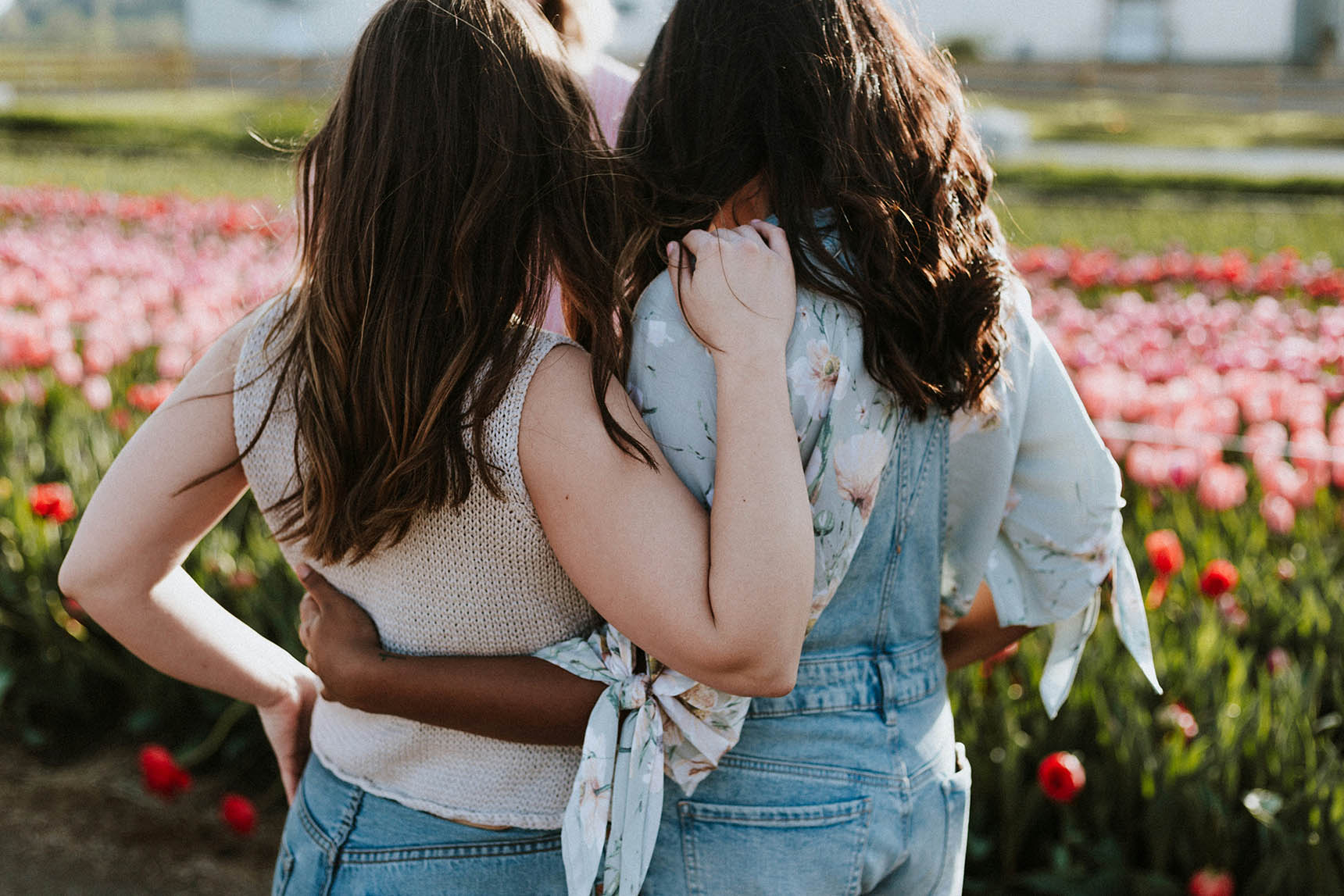 Two Girls Are Hugging Each Other On A Flower Field